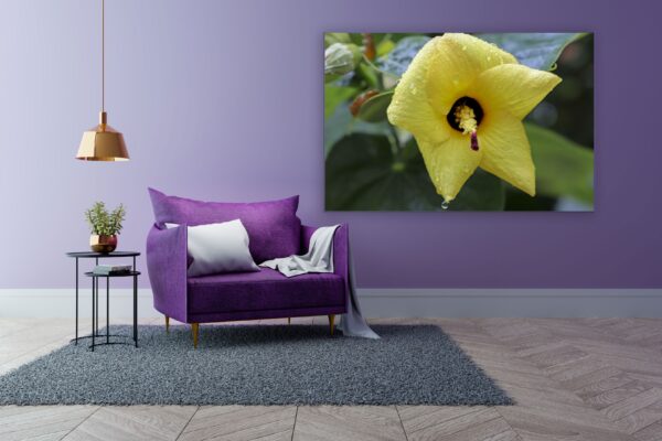 A purple chair and table in front of a yellow flower.