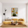 A living room with yellow furniture and a vase of flowers.