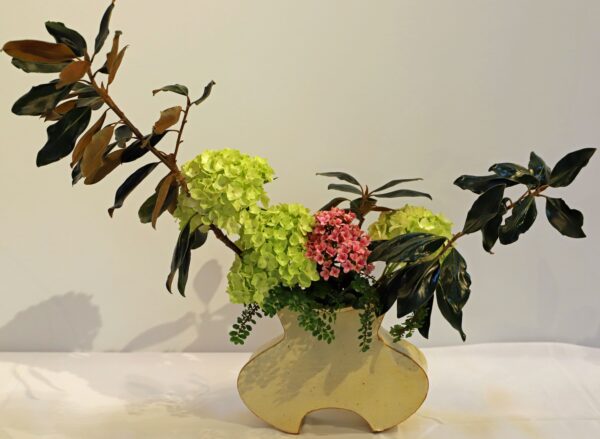 A vase with flowers and leaves in it