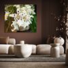 A living room with white furniture and a large painting.