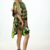 Woman in green dress posing confidently.